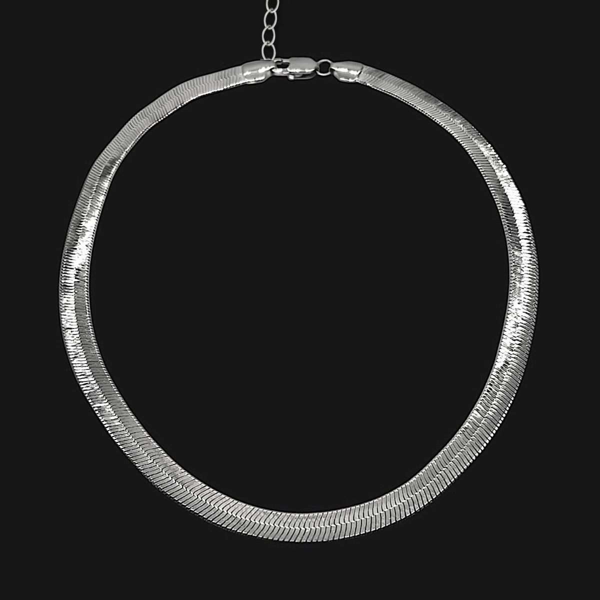 Wide 7mm Sterling silver herringbone chain necklace featuring a sleek, flat silhouette, fluid drape and luminous polished silver finish.