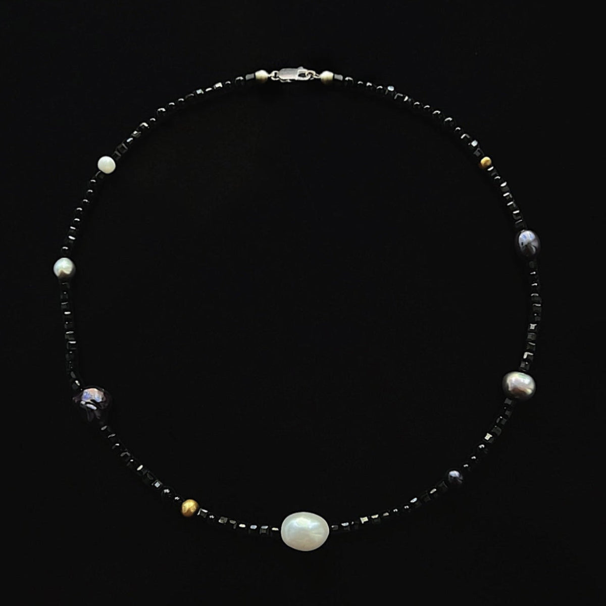 Halo 16-inch pearl collar necklace featuring faceted black spinel, polished black onyx and white, grey and black pearls in a refined gemstone design.
