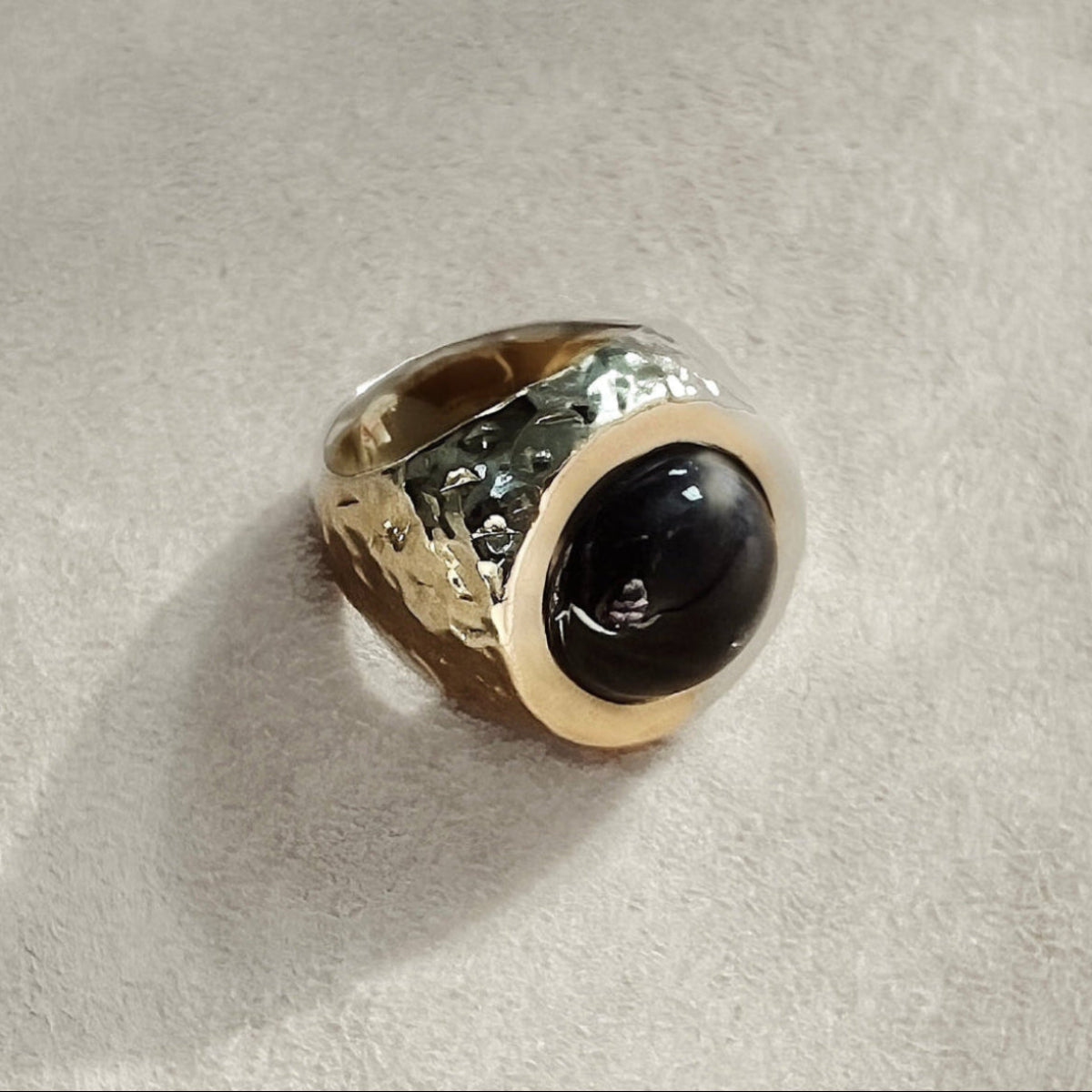 gold hammered signet ring featuring a black moonstone cabochon.