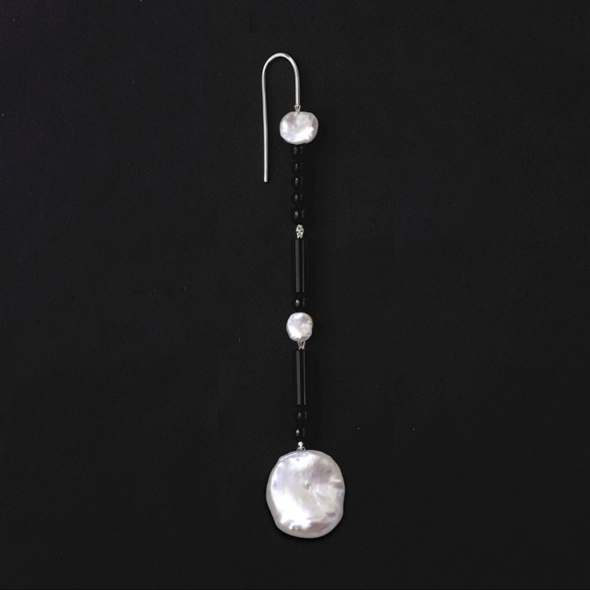 Lucent long statement earrings featuring polished black onyx beads, white baroque freshwater pearl drops and Sterling silver ear wires.
