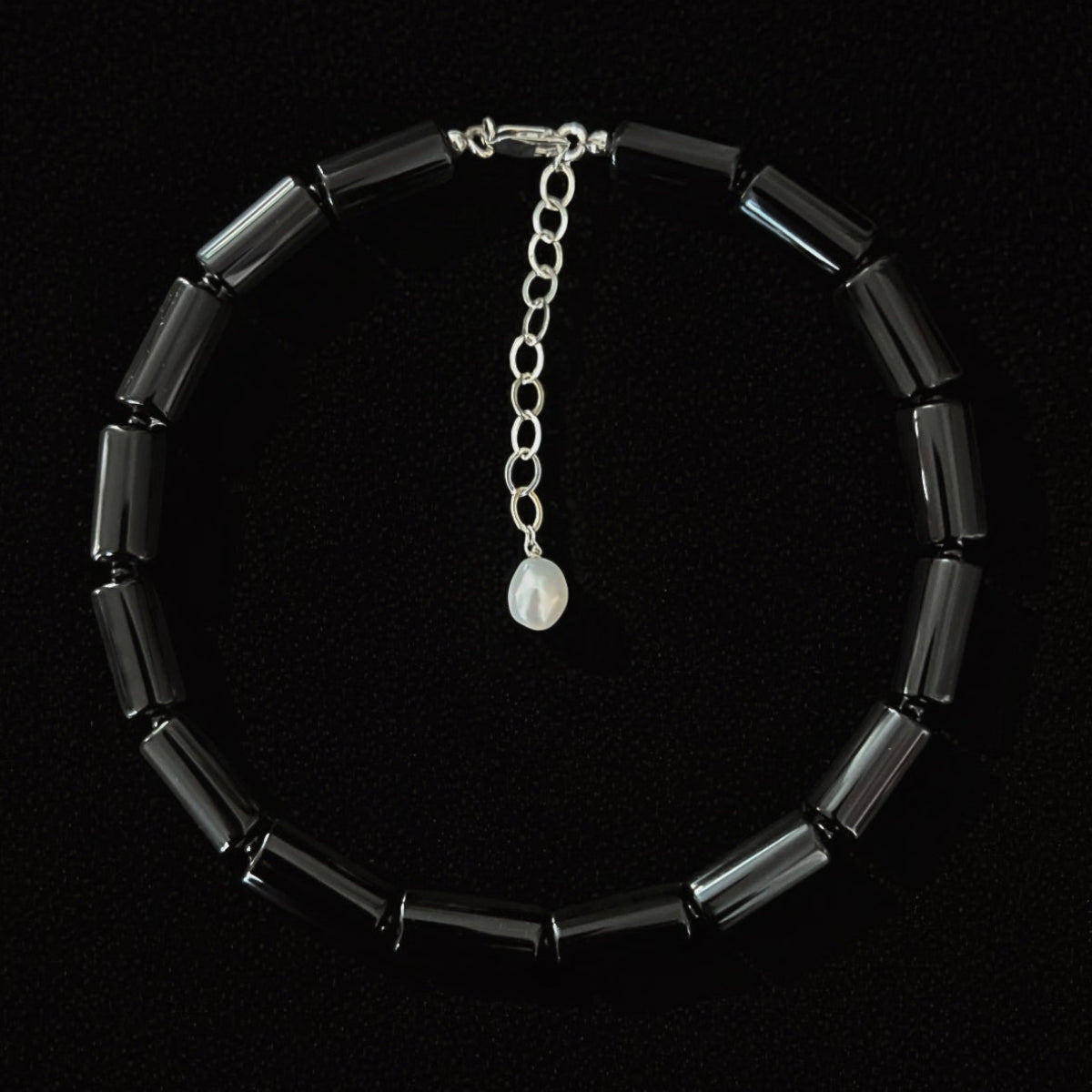 Women's Lucent collar necklace featuring natural onyx cylinder beads, a pearl, silver accents, and an adjustable 16–22 inch length. Handcrafted luxury modern heirloom jewelry.