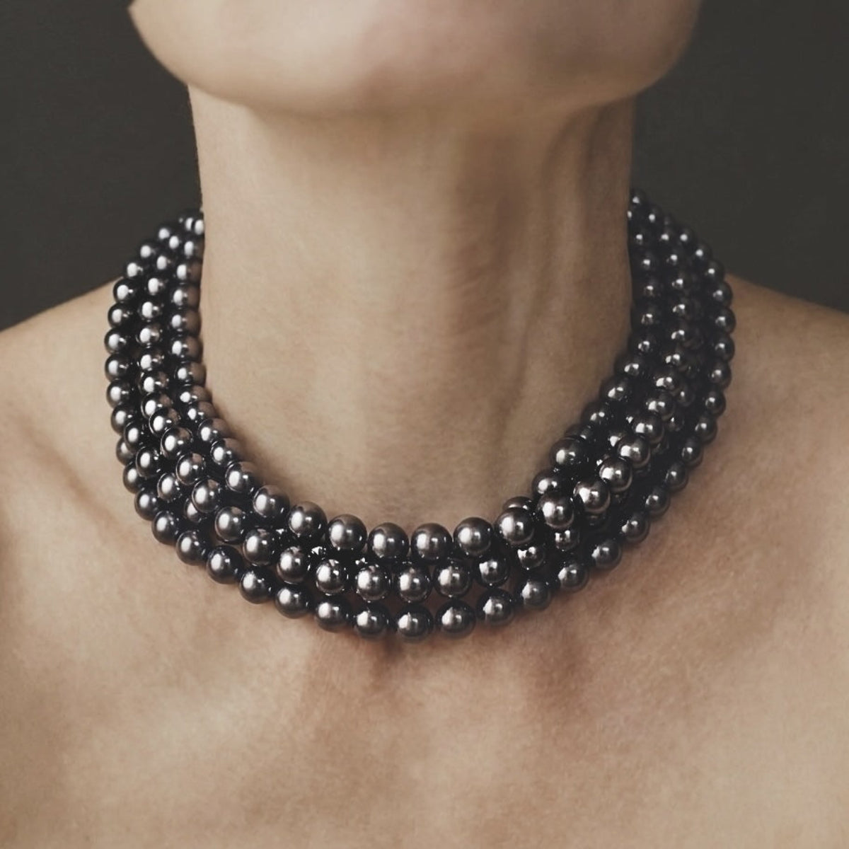 Strata luxury multi-strand statement collar necklace featuring polished hematite beads in a layered design.