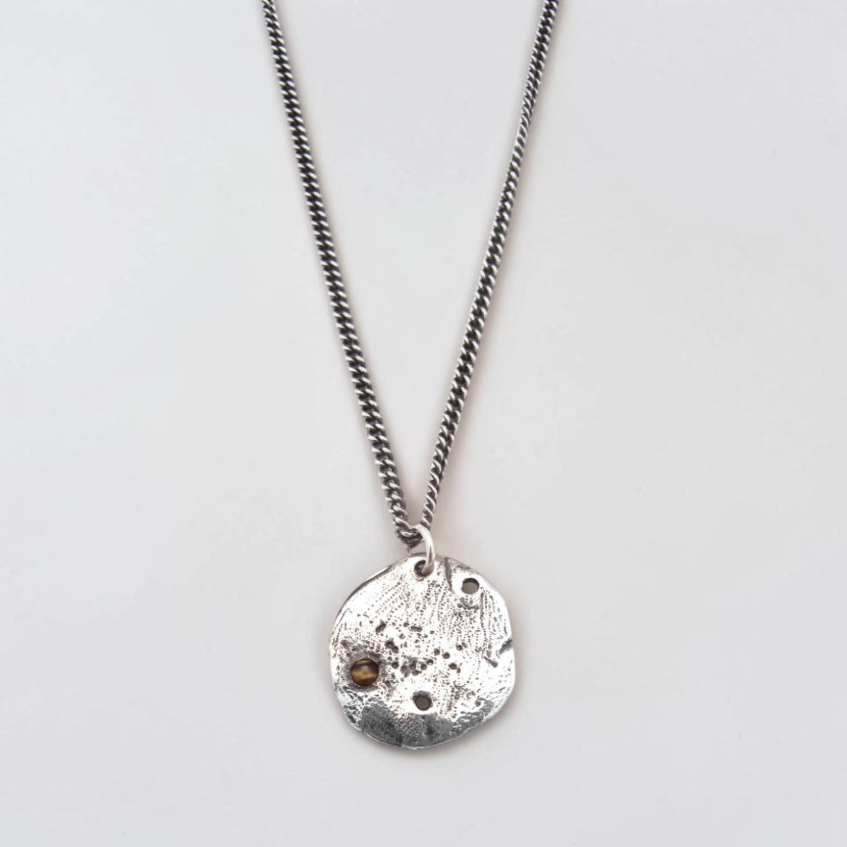 Silver Relic Coin necklace pendant for men with bezel-set Tiger's Eye cabochon on a 24-inch curb chain necklace.