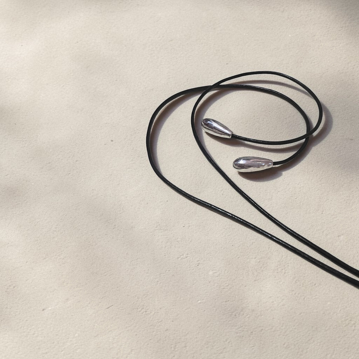Hand-carved clear quartz Scarab pendant wrapped in Sterling silver wire, suspended from a 26-inch black silk cord with silver teardrop accents.