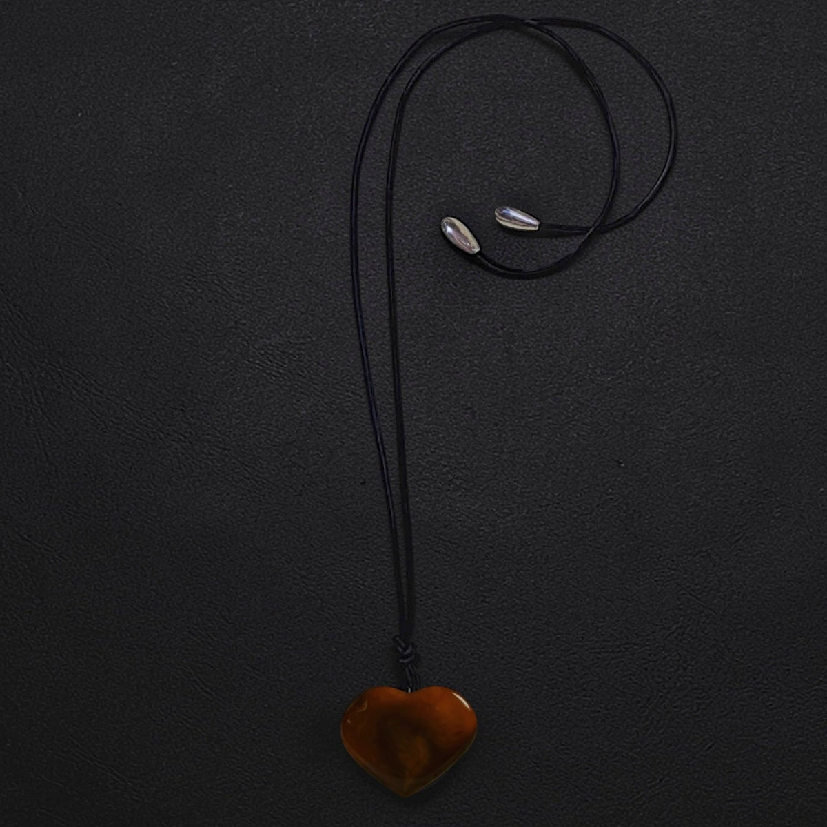 Limited edition oversized carnelian heart pendant on black leather cord with sterling silver teardrop ends, worn as a long statement necklace or choker