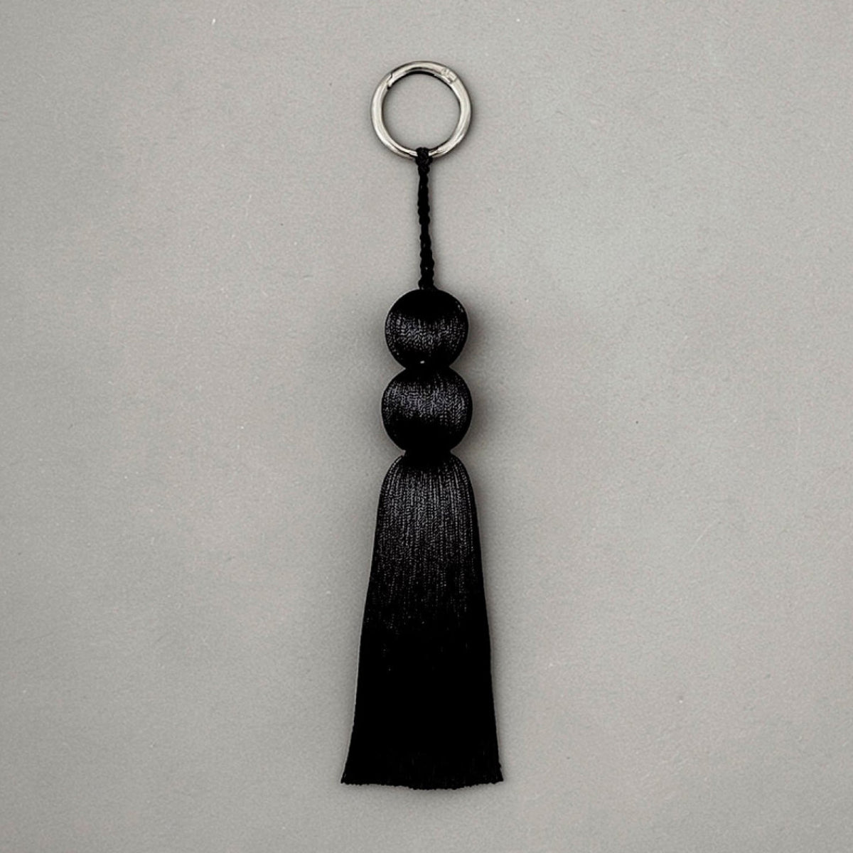 Coline tassel charm in sterling silver, sculptural luxury bag charm and keychain with fluid silhouette