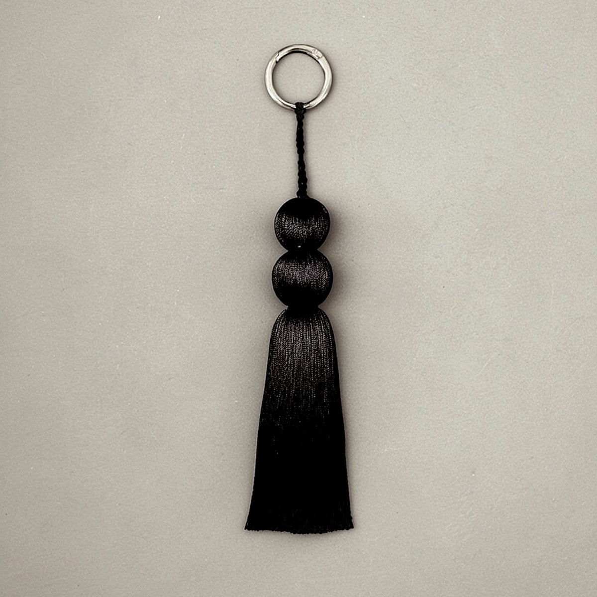 Coline tassel charm in sterling silver, sculptural luxury bag charm and keychain with fluid silhouette