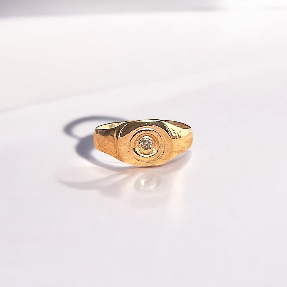 Eros men's pinky ring in solid 14K gold with a 0.60 carat bezel-set diamond, inspired by ancient coin relics and handcrafted in Los Angeles.