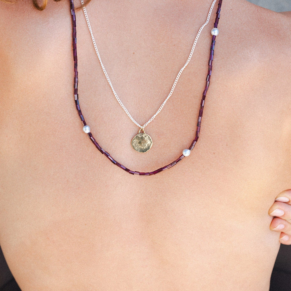 
                  
                    The Grecian coin pendant necklace layered with a long pearl necklace for women.
                  
                
