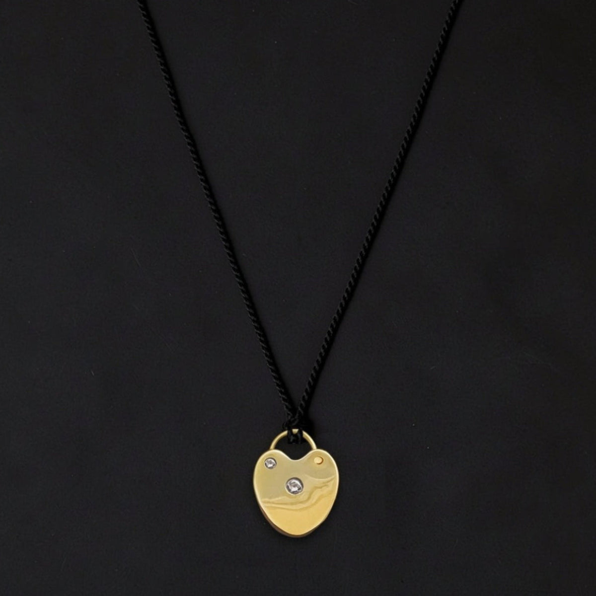 Luxury Heart Lock pendant necklace featuring a sculptural gold-plated heart with bezel-set diamonds, suspended from an adjustable silk cord.