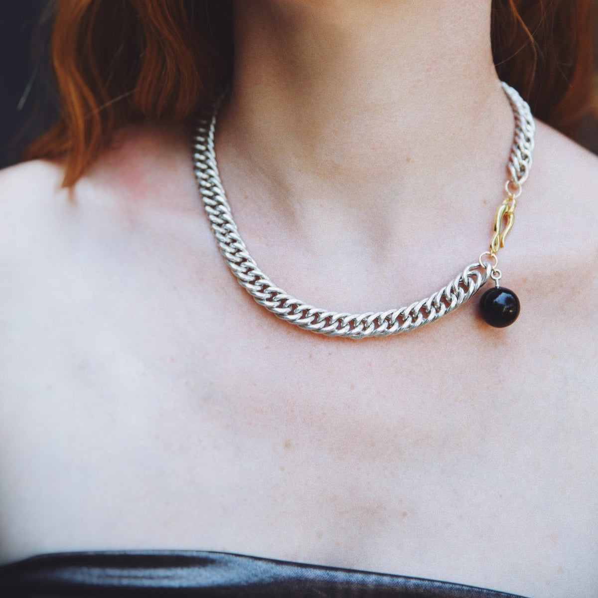 A modern chunky chain necklace in sterling silver with an onyx orb as accent.