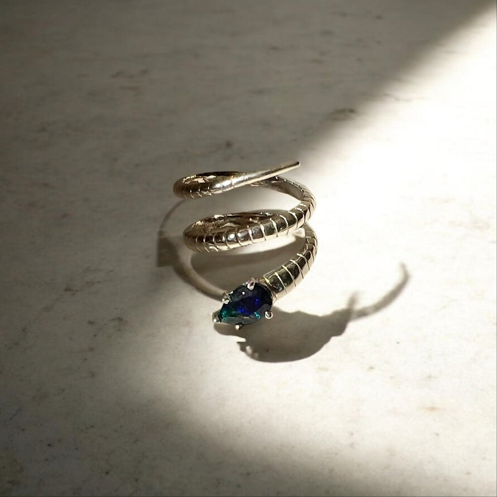 A silver snake ring with a black opal.